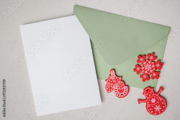 Fototapeta Christmas background. Empty white blank greeting or invitation card with envelope and Christmas decoration on concrete texture background.