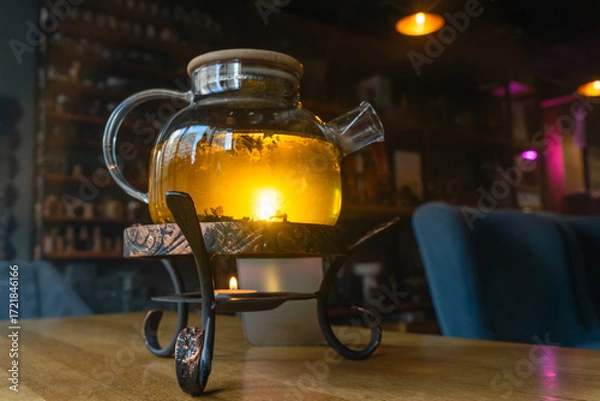 Obraz Golden hour tea ritual featuring herbal tea in a glass teapot symbolizing harmony warmth and shared moments of joy. Tranquil tea moment with herbal infusion in a clear teapot surrounded.