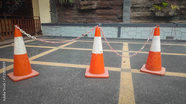 Fototapeta Three Orange Traffic Cones Connected by Chain
