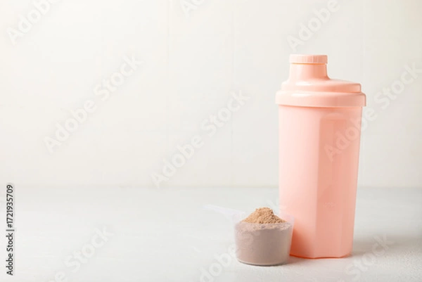 Fototapeta Protein shake with protein powder on a colored background. The powder is mixed with water or milk. A dietary supplement for a balanced diet. Whey protein. Fitness and gym diet nutrition.