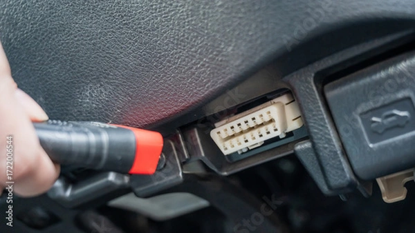 Obraz Woman using OBD2 diagnostic scanner. 