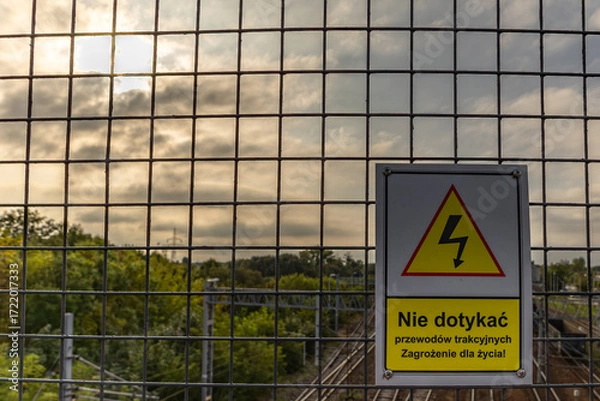 Fototapeta High voltage warning sign, warning sign hanging above the railway tracks Poland