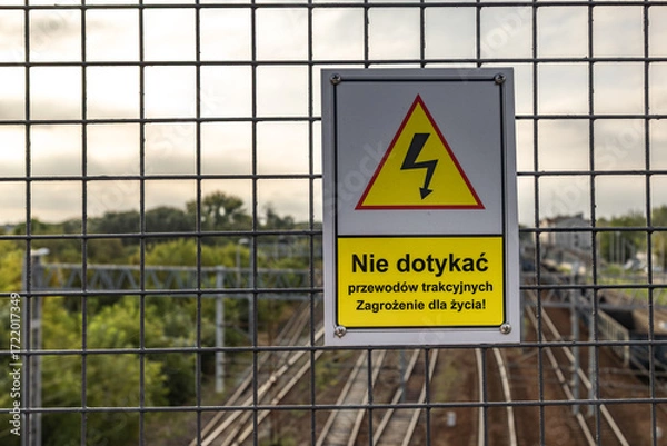 Fototapeta High voltage warning sign, warning sign hanging above the railway tracks Poland