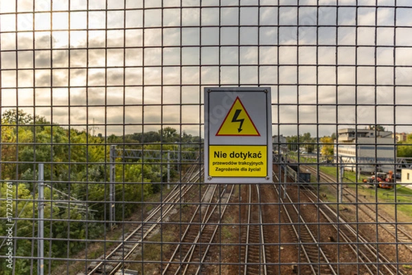 Fototapeta High voltage warning sign, warning sign hanging above the railway tracks Poland