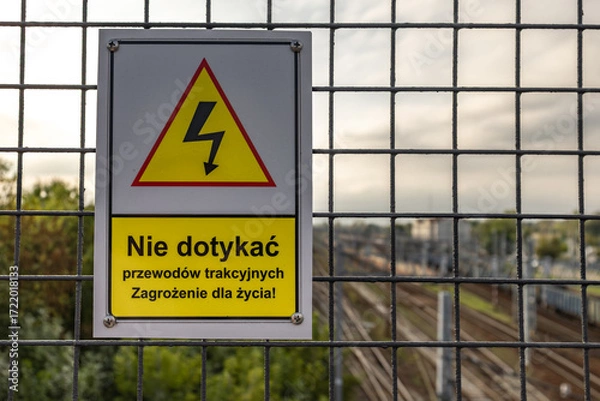 Fototapeta High voltage warning sign, warning sign hanging above the railway tracks Poland