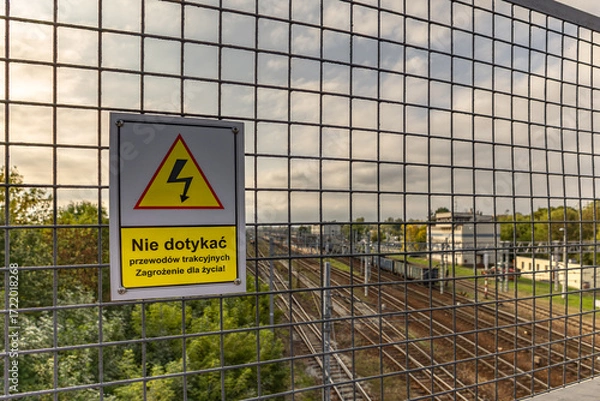 Fototapeta High voltage warning sign, warning sign hanging above the railway tracks Poland