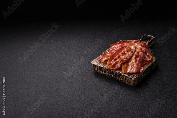 Fototapeta Fried pork bacon slices or strips as a breakfast ingredient. Fried bacon