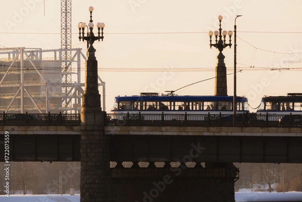 Obraz An old tram crosses a bridge on a cold winter evening