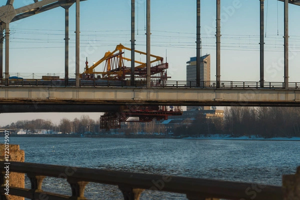 Obraz Detail of an iron-framed bridge crossing a river in a snowy winter