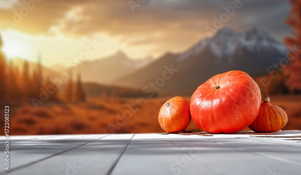Fototapeta Rustic autumn still life with pumpkins placed on wooden table, blurred fall landscape with autumn background. Seasonal marketing, farm-to-table concepts and thanksgiving themes.