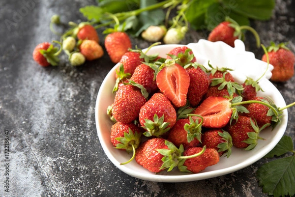 Fototapeta Fresh summer strawberries in white bowl on dark rustic surface