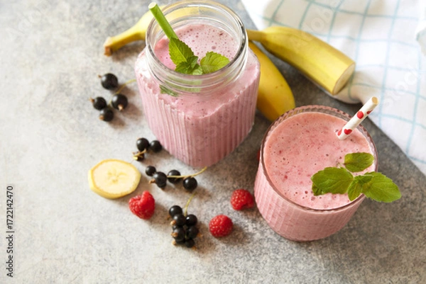 Fototapeta Refreshing mixed berry and banana smoothie with mint garnish. Copy space.