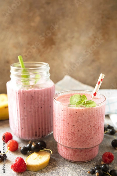 Fototapeta Refreshing mixed berry and banana smoothie with mint garnish. Copy space.