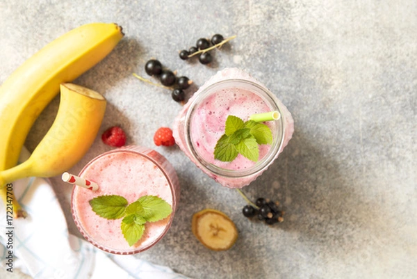 Fototapeta Refreshing mixed berry and banana smoothie with mint garnish.