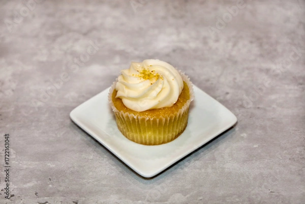 Fototapeta Close-up view of a vanilla cupcake with buttercream frosting.