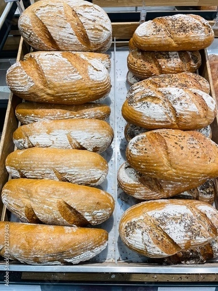 Fototapeta Food commerce and everyday shopping. Sale of bread with a close-up view of bakery products on shelves in a store or bakery.