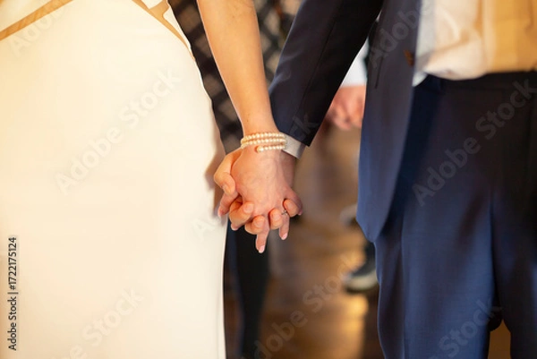 Fototapeta Romantic connection and emotional bonding. A couple holding hands symbolizing love, attachment and healthy relationships. St. Valentine background. No faces.