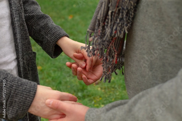 Fototapeta Romantic connection and emotional bonding. A couple holding hands symbolizing love, attachment and healthy relationships. St. Valentine background. No faces.