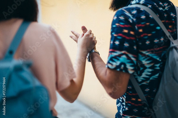 Fototapeta Romantic connection and emotional bonding. A couple holding hands symbolizing love, attachment and healthy relationships. St. Valentine background. No faces.
