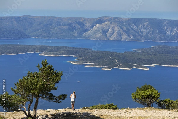Fototapeta Young woman on Vidova Gora highest peak on island Brac and island Hvar in background, Dalmatia, Croatia