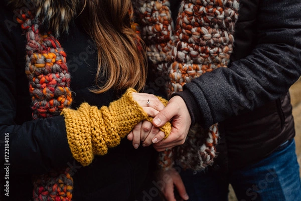 Fototapeta Romantic connection and emotional bonding. A couple holding hands symbolizing love, attachment and healthy relationships. St. Valentine background. No faces.
