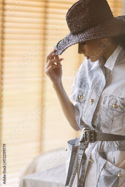 Fototapeta A mysterious woman in an eclectic, avant-garde look combines western and glam styles.