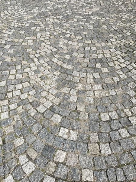 Fototapeta Cobblestone pavement featuring an intricate circular pattern that draws the eye