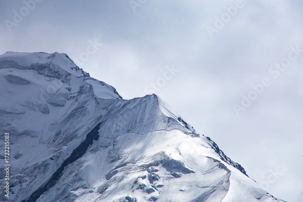 Fototapeta A close-up of a mountain peak in bad weather, leading to the death of climbers in windy weather, snow-capped peaks in the clouds