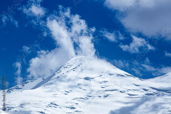 Fototapeta A close-up of a mountain peak in bad weather, leading to the death of climbers in windy weather, snow-capped peaks in the clouds