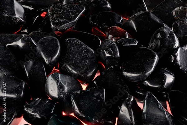 Fototapeta Black polished stones texture background and red light