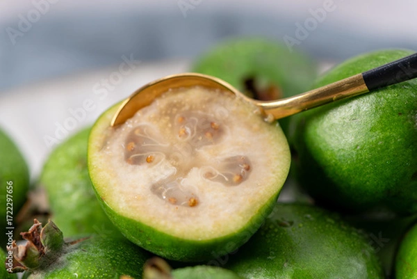 Fototapeta Extreme close-up of a feijoa with a golden spoon