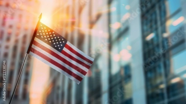 Fototapeta A striking american flag flowing elegantly in the wind above a majestic urban cityscape view