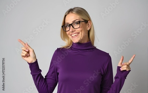Fototapeta Middle age beautiful blonde woman wearing casual purple turtleneck sweater and glasses smiling and looking at the camera pointing with two hands and fingers to the side. High quality