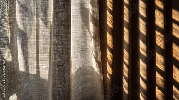 Fototapeta Soft sunlight through wooden slats casting striped shadows on fabric curtain, creating textured pattern and negative space, perfect for minimal interior, home decor, and background design.