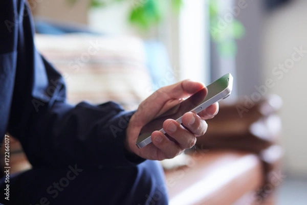 Fototapeta スマートフォンを操作する日本人シニア男性の手元