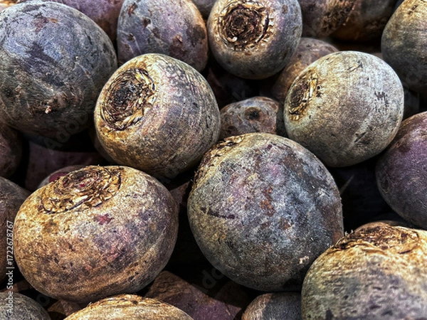 Fototapeta Close-up view of fresh raw beetroots with textured skins displayed in a market pile