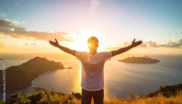 Fototapeta A person with arms outstretched, enjoying a sunset over a tranquil bay