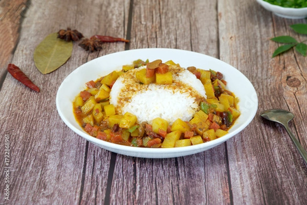 Obraz Rice topped with potato on wooden table, star anise, pepper. Close-up