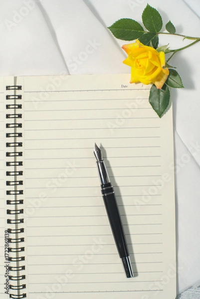 Obraz Notebook on the white desk, black pen, yellow rose flowers. Copy space
