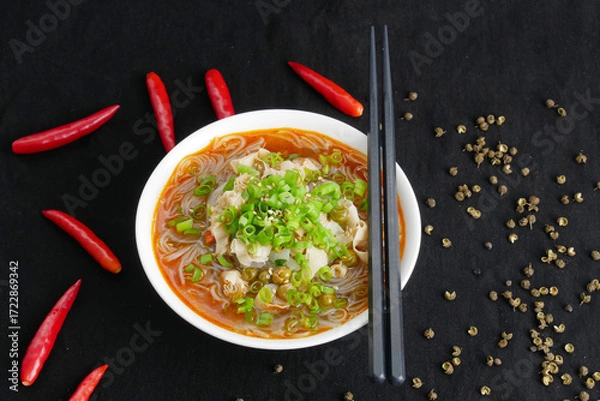 Obraz Close-up hot and sour rice noodle soup on black background, top view