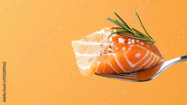 Fototapeta Fresh salmon fillet on fork garnished with rosemary and sea salt, set against vibrant orange background, evokes sense of culinary delight