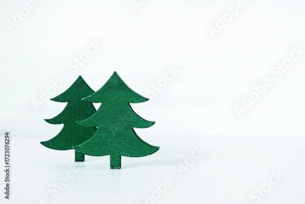 Fototapeta wooden miniature Christmas tree placed against a rustic gray wooden background.