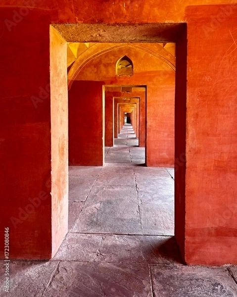 Fototapeta A long series of arched passages – the illusion of an endless corridor,