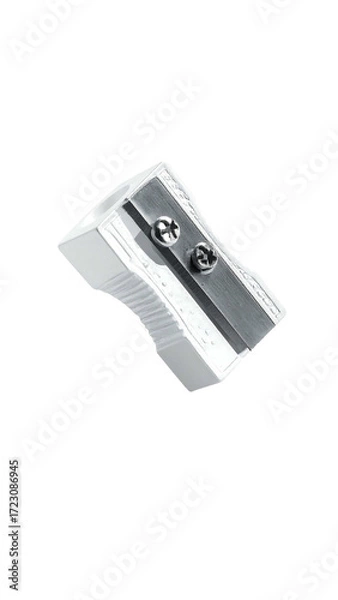 Fototapeta A small, white, rectangular pencil sharpener with a metallic grey blade and two visible screws.  It's compact and designed for easy pencil sharpening