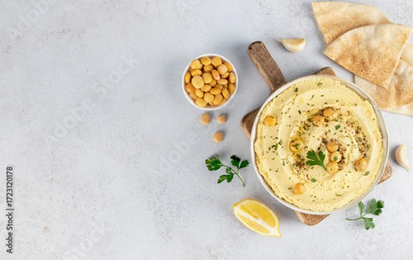 Fototapeta Lupini bean hummus with olive oil, herbs and pita on white background. Top view. Copy space. Vegan food.