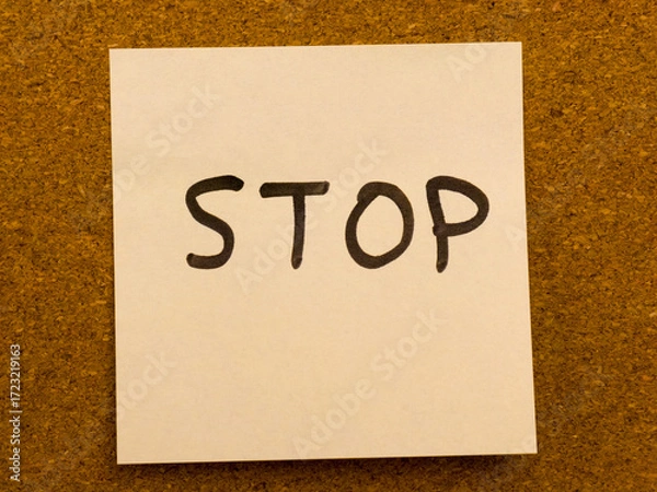 Fototapeta Handwritten stop message on sticky note pinned to cork board