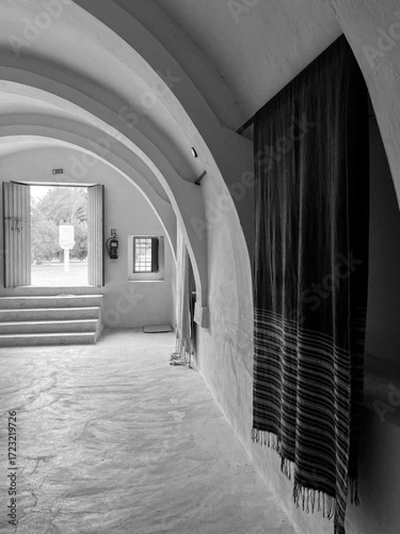 Fototapeta Inside a traditional building in Djerba, Tunisia, the smooth arched ceilings create a serene atmosphere, complemented by hanging woven textiles, inviting visitors to appreciate local craftsmanship.