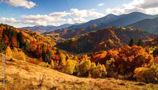 Fototapeta Vibrant autumn landscape showcases colorful foliage in tranquil valley surrounded by mountains in late afternoon light