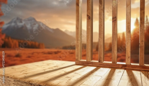 Fototapeta Empty wooden patio surface outdoors with warm autumn sunlight rays shining across the scene with copy space for product placement. The blurred autumn background and cozy seasonal mood. 