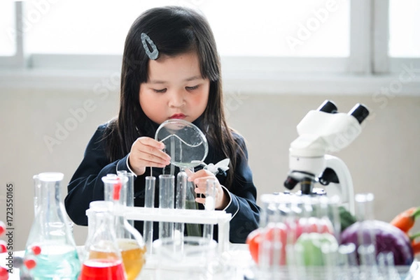 Fototapeta Asian little cute girl students. Girl doing science experiment science classroom. Education research and development concept learning kids.